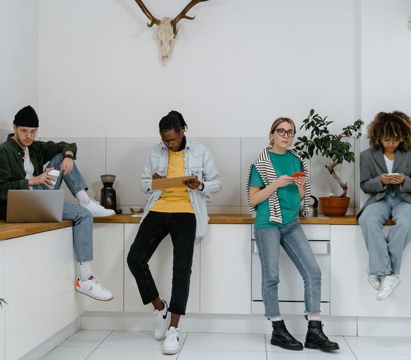 A diverse group of people looking focused and relaxed in a modern setting.